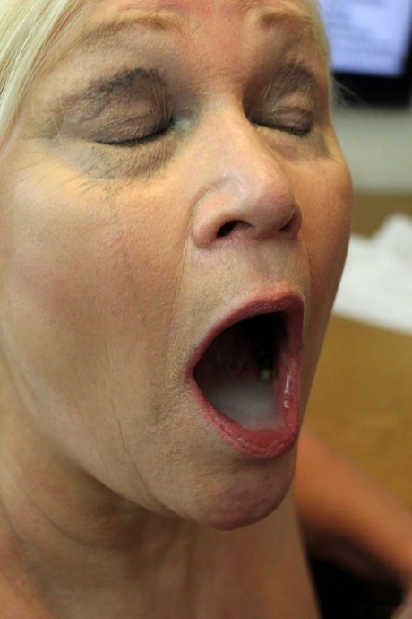 Big boobed granny sports a mouthful of cum after anal sex in her office