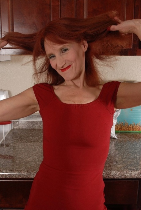 Redhead granny Debra is lying naked on the floor and masturbating